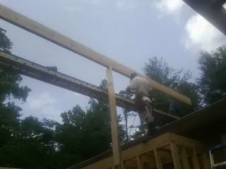 Carpenter setting a ridge beam over a new addition frame — Ice Dam Removal by Roofing Brothers in Mound City