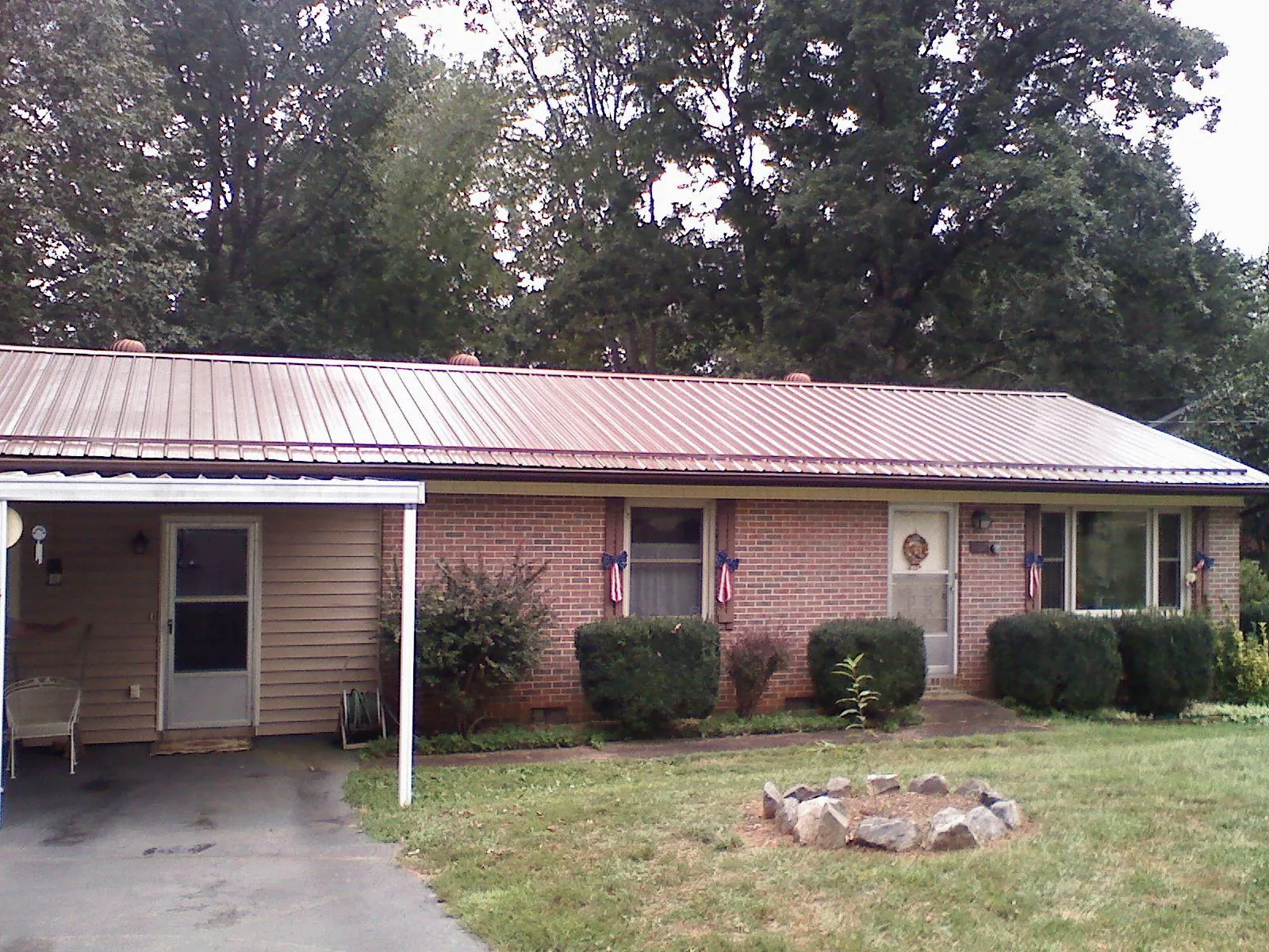 Bronze metal roof and carport on a brick ranch home — Roof Repair work by our crew in Mound City